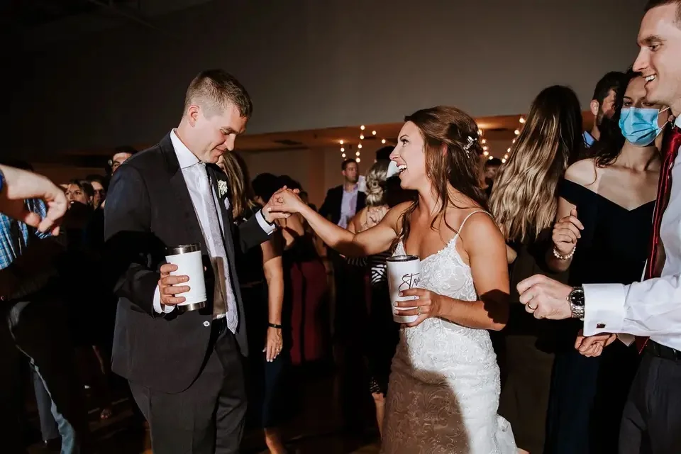 Bride and groom dancing together with guests during a Michigan wedding reception