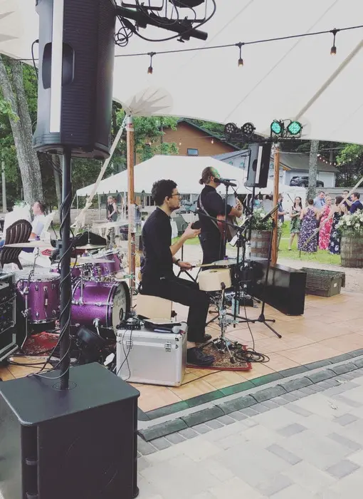 Weekend ComeBack performing acoustic cocktail hour music under a tent at a Michigan waterfront wedding