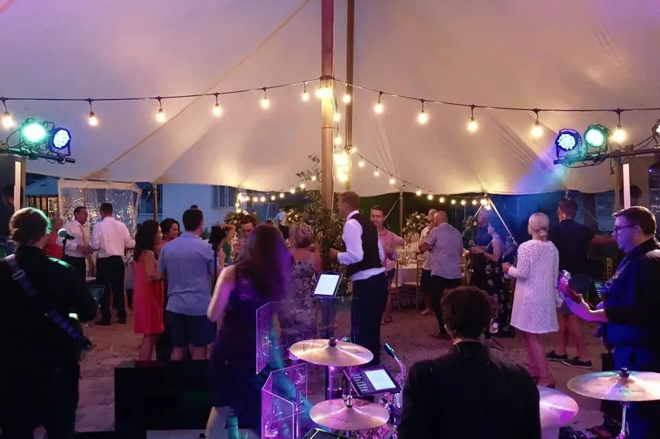 Tent wedding dance floor by the water with Weekend ComeBack set up for a Michigan wedding reception