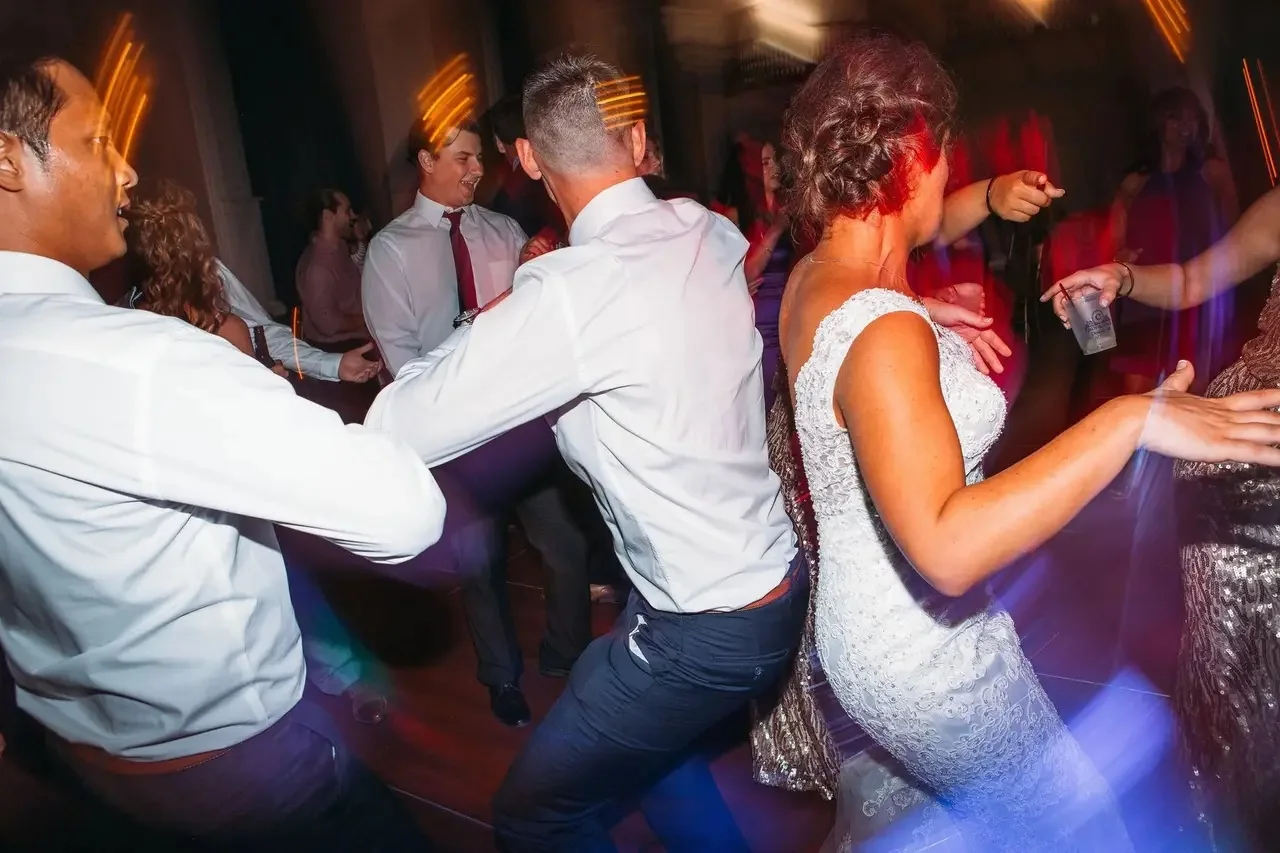 Packed dance floor at a Michigan wedding reception with guests dancing around the bride
