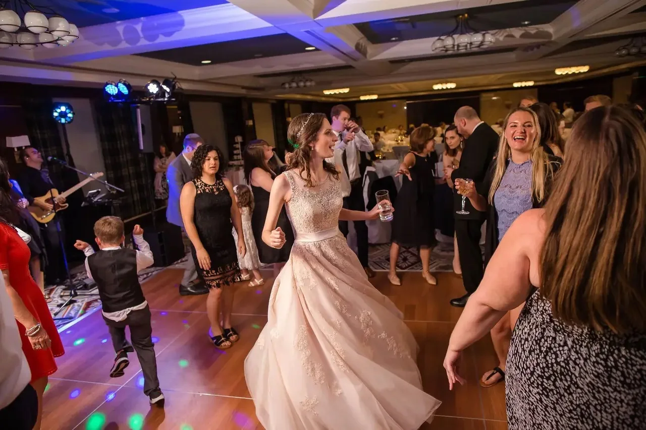 Groom dancing with guests while Weekend ComeBack performs at a Michigan wedding reception