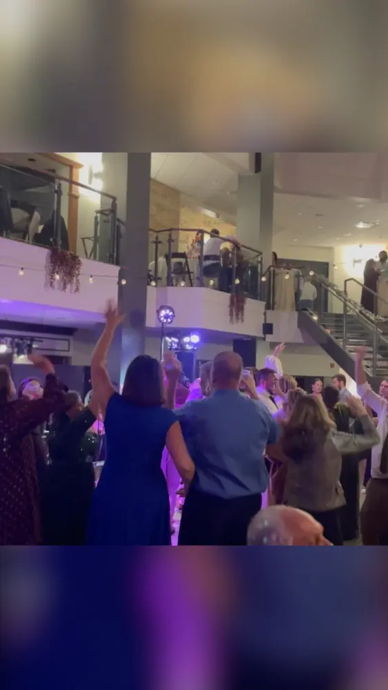Packed wedding dance floor with live band performance