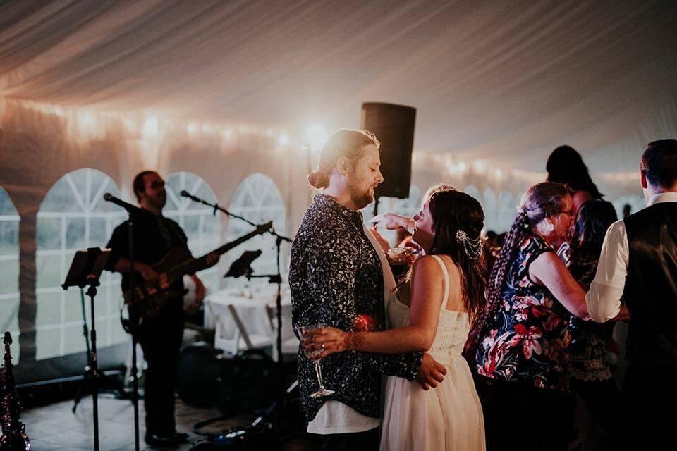 Couple sharing a dance at a Michigan backyard wedding with Weekend ComeBack performing live
